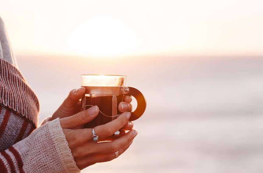 Drink warm tea by the beach